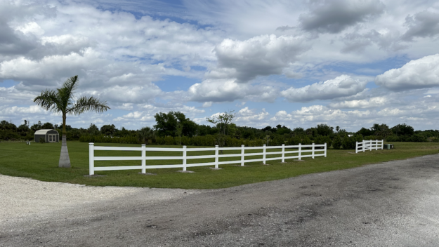 Install a vinyl fence that beautifully encloses a residential property in Southwest Florida, showing resilience and style.